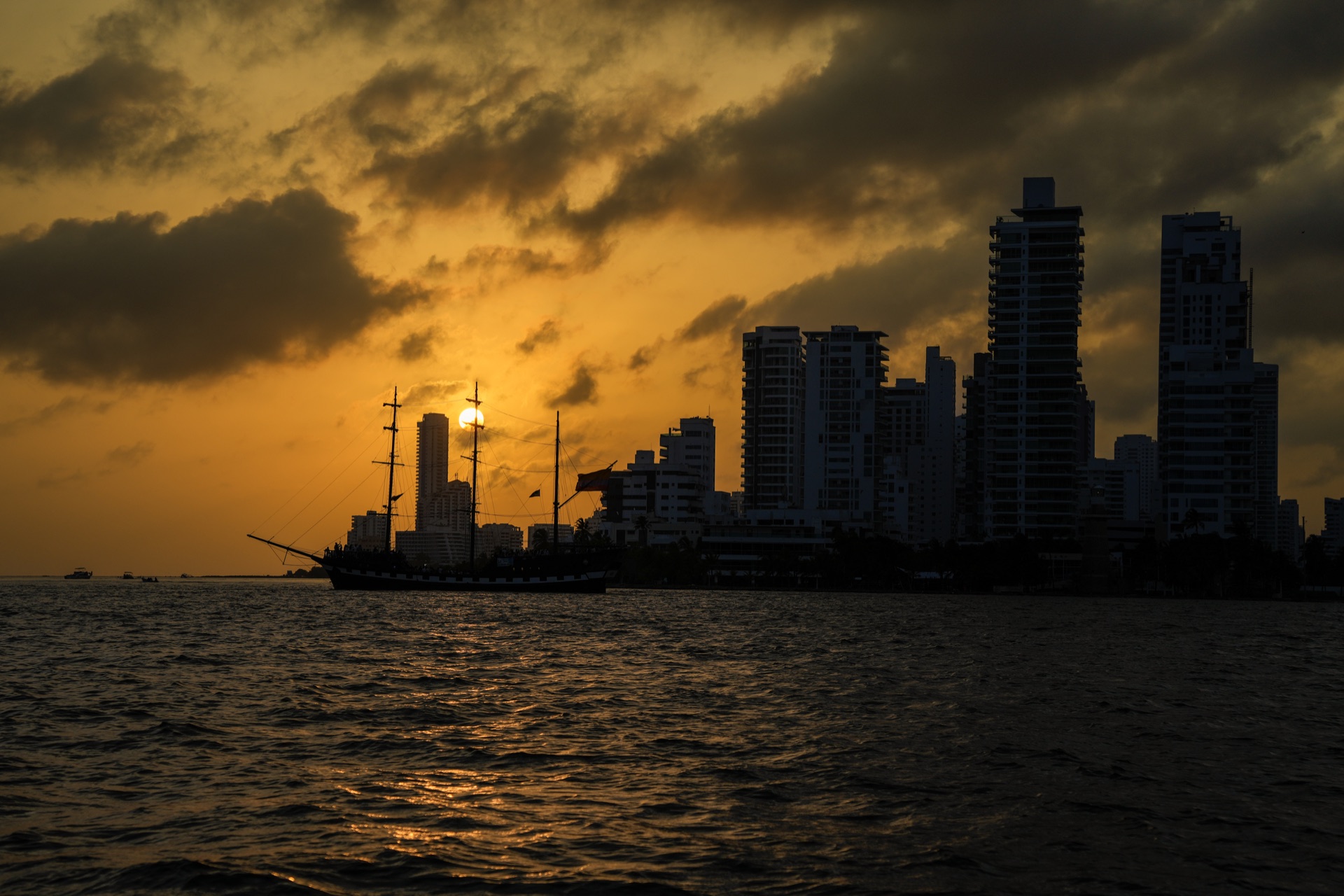 Atardecer sobre la bahía de Cartagena con un galeón frente al skyline