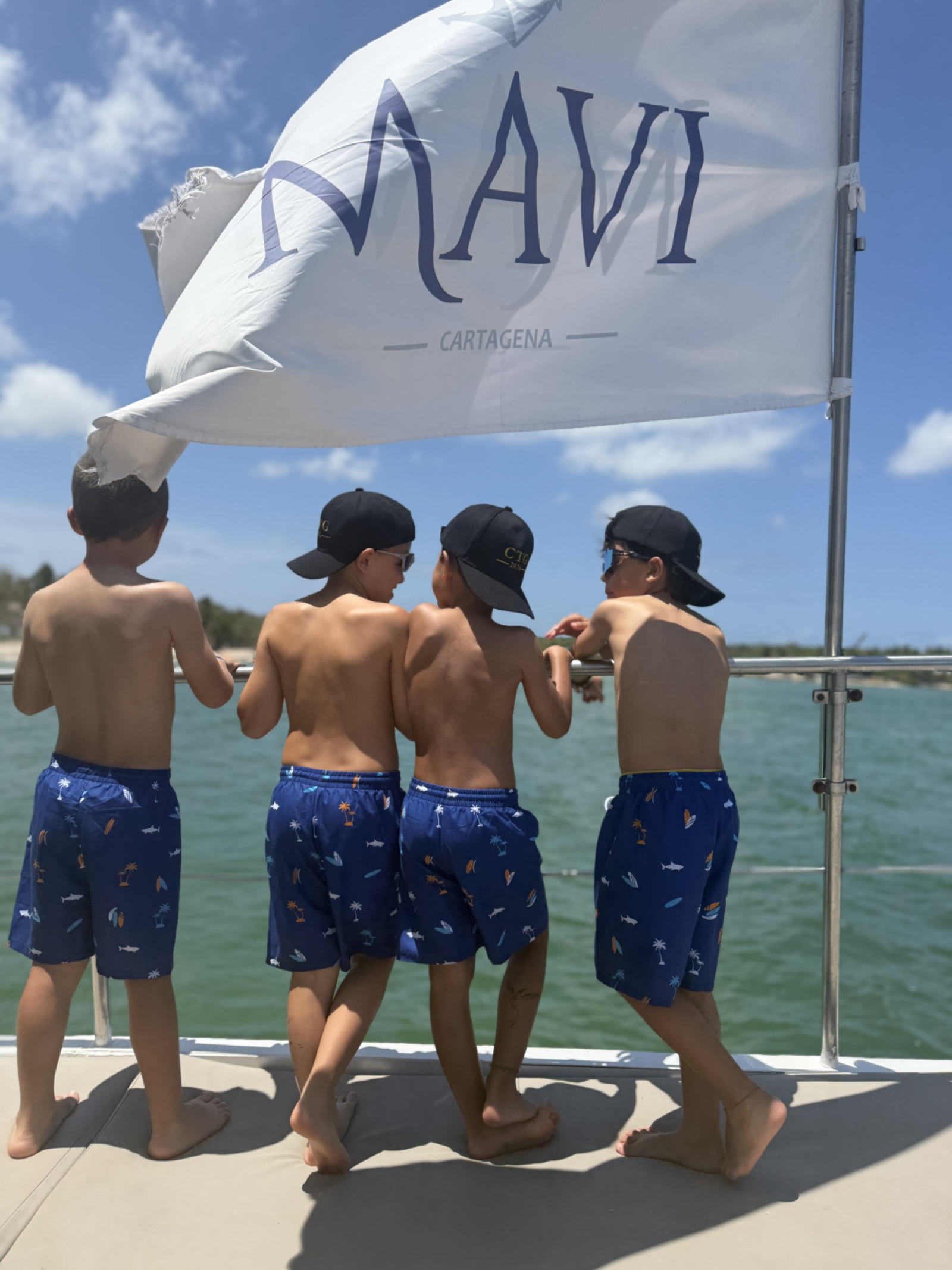 Niños mirando el mar desde una embarcación MAVI bajo la bandera de la marca